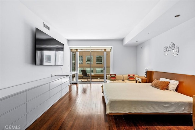 bedroom featuring access to outside, visible vents, and wood finished floors