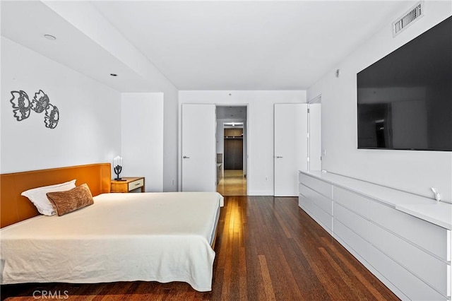 bedroom with dark wood-style flooring and visible vents