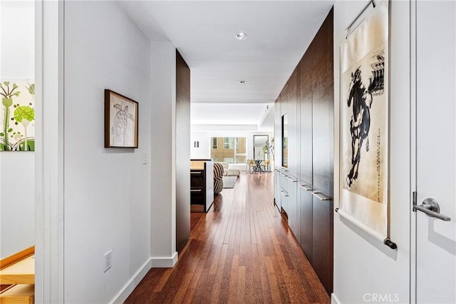 hall with dark wood-style floors and baseboards