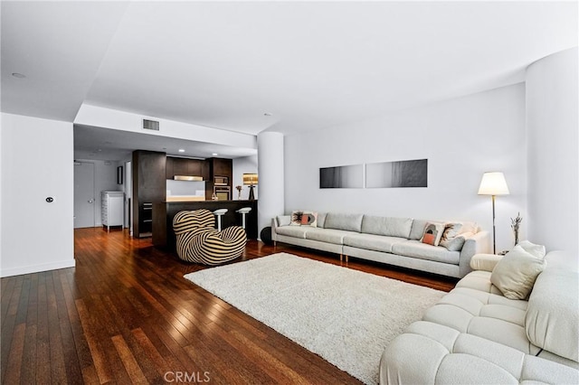 living area with dark wood-style floors and visible vents