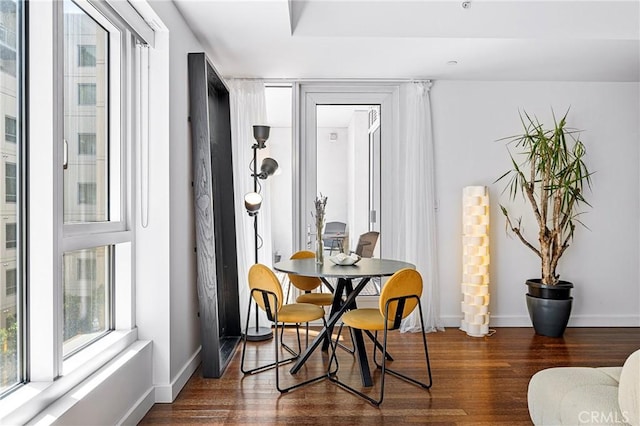 dining space featuring dark wood-style floors and baseboards