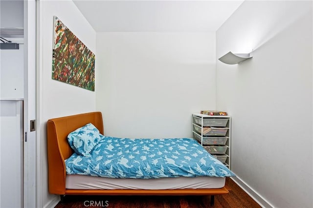 bedroom with baseboards and wood finished floors