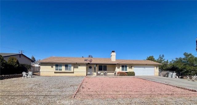 ranch-style home featuring a chimney, stucco siding, concrete driveway, fence, and a garage