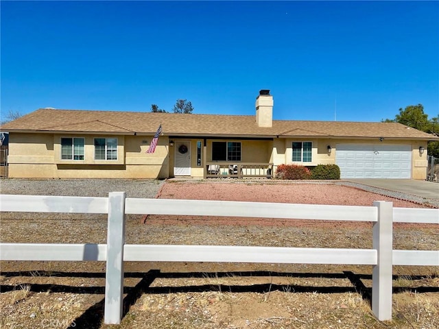 ranch-style home with a fenced front yard, concrete driveway, a garage, and stucco siding