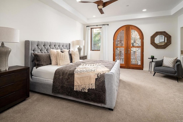 bedroom featuring a tray ceiling, french doors, recessed lighting, light carpet, and access to outside