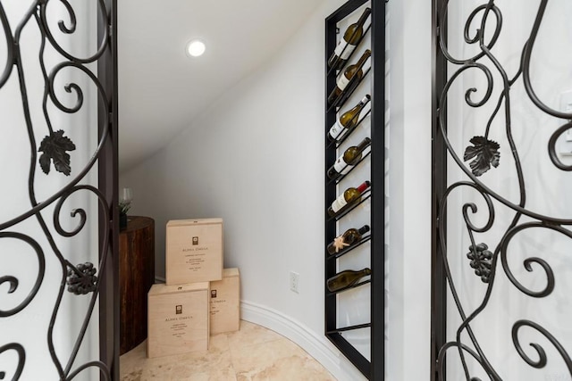 wine room with lofted ceiling and baseboards