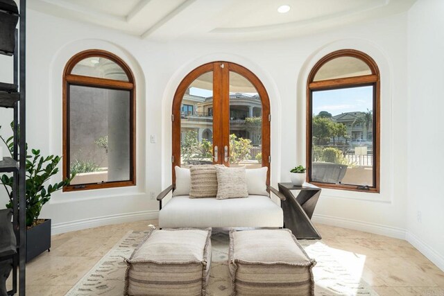 living area featuring baseboards and french doors