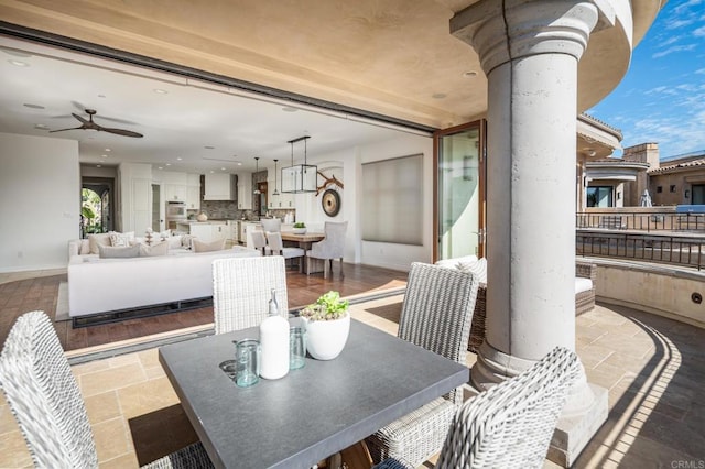 dining area with stone tile floors, recessed lighting, baseboards, ceiling fan, and ornate columns