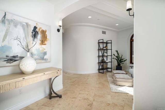 hall featuring arched walkways, recessed lighting, visible vents, and baseboards