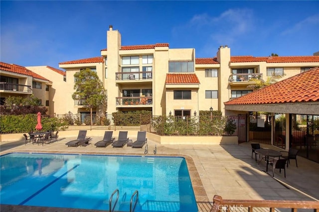 community pool featuring a patio and fence