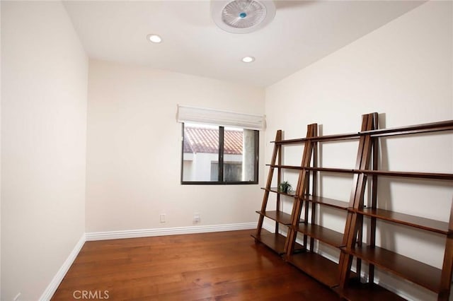 unfurnished room featuring recessed lighting, dark wood finished floors, and baseboards