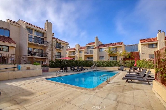 community pool featuring a patio and fence