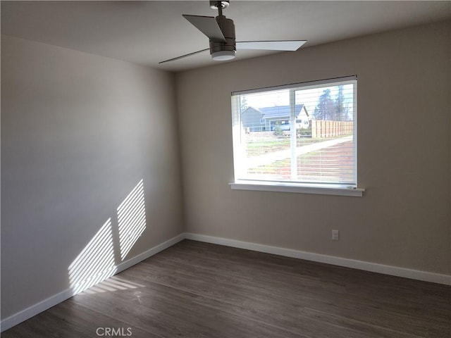 empty room with baseboards, a ceiling fan, and wood finished floors