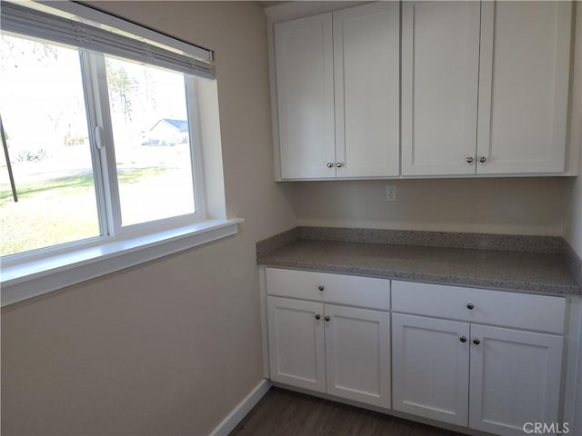 laundry area featuring baseboards and dark wood finished floors
