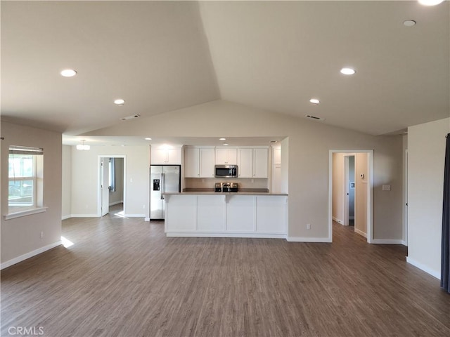 kitchen featuring wood finished floors, lofted ceiling, stainless steel appliances, white cabinetry, and open floor plan
