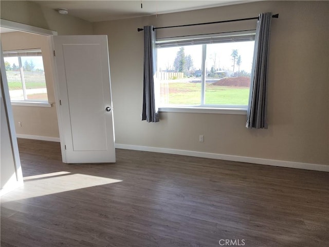 unfurnished room with baseboards and wood finished floors