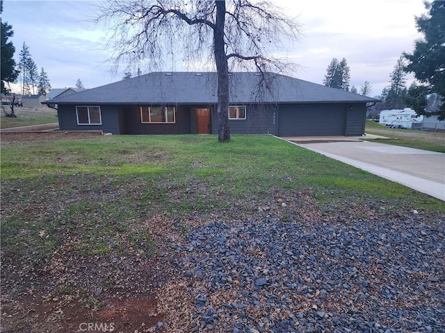 ranch-style house featuring a garage, a front lawn, and concrete driveway