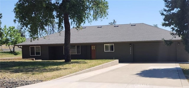 ranch-style home featuring a garage, a front lawn, and concrete driveway