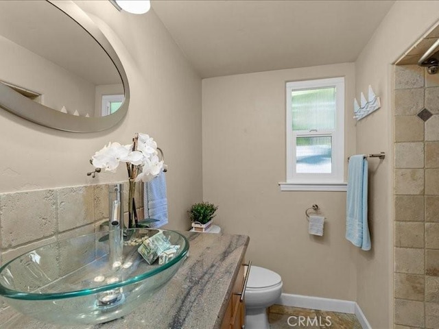 bathroom with vanity, toilet, and baseboards