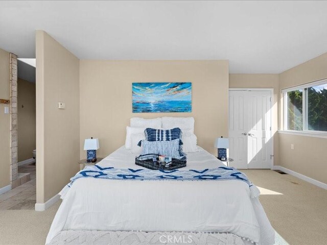 carpeted bedroom featuring a closet and baseboards