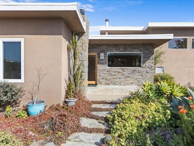 view of home's exterior featuring stone siding and stucco siding