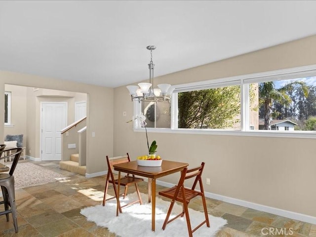 dining space with a wealth of natural light, stairway, baseboards, and an inviting chandelier