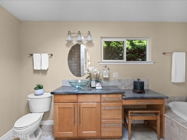 full bath with tile patterned floors, tiled tub, toilet, and vanity