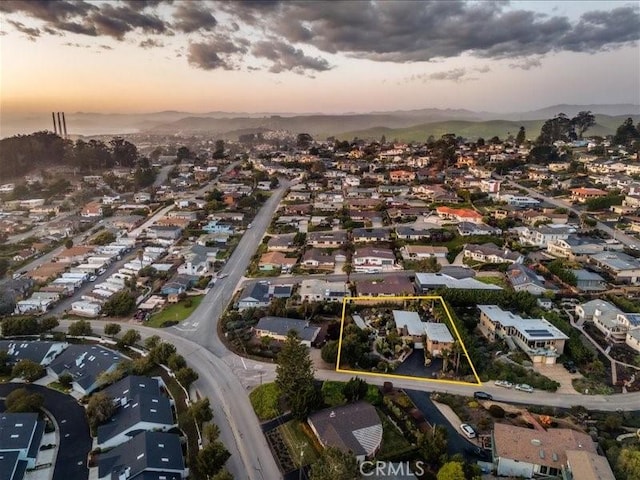 aerial view at dusk featuring a residential view and a mountain view