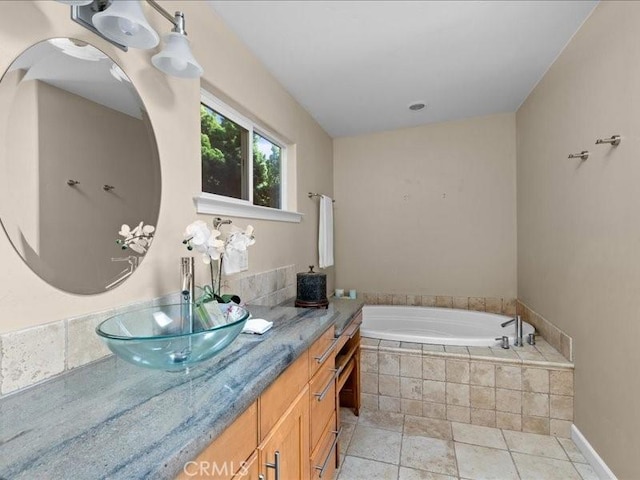 full bath featuring vanity, a bath, and tile patterned flooring