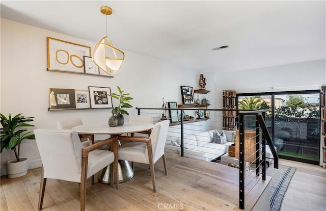 dining room featuring wood finished floors, visible vents, and baseboards