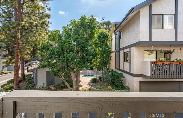 view of side of property featuring a balcony and stucco siding