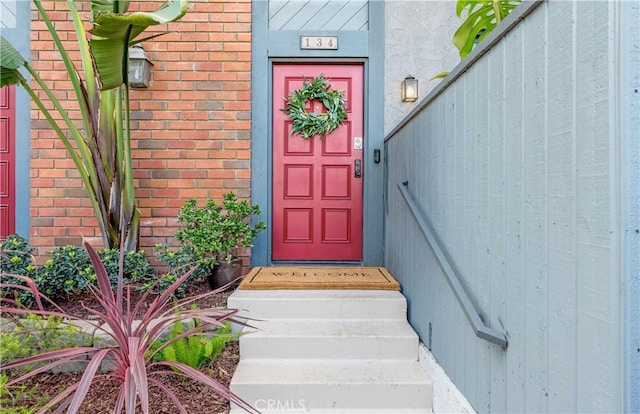 view of exterior entry with brick siding