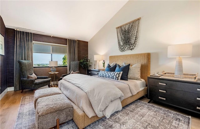 bedroom with vaulted ceiling and light wood-style flooring