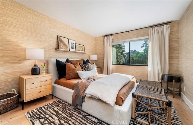 bedroom featuring wallpapered walls, light wood-style flooring, and baseboards