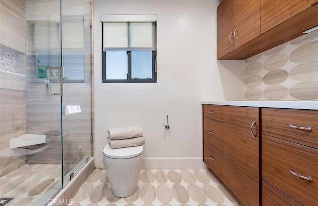 full bathroom featuring vanity, a shower stall, toilet, and baseboards