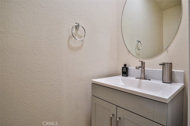 bathroom featuring a textured wall and vanity