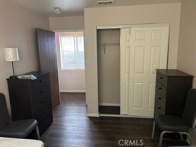 living area with baseboards, visible vents, and dark wood-style flooring