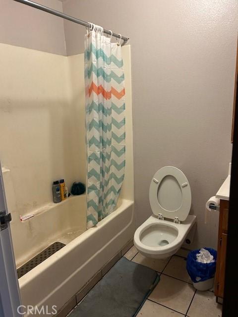 bathroom with shower / bath combo, toilet, and tile patterned floors