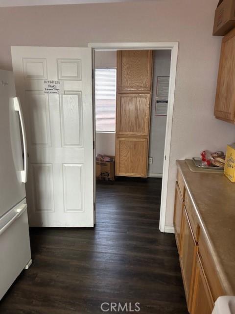 kitchen featuring freestanding refrigerator and dark wood finished floors