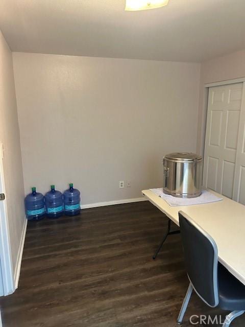 home office with dark wood-style flooring and baseboards