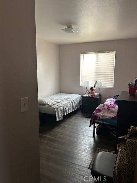 bedroom with dark wood-style flooring