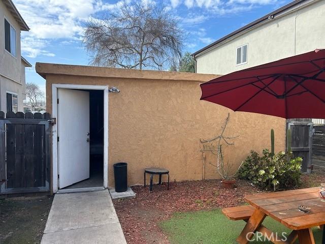 doorway to property with fence and stucco siding