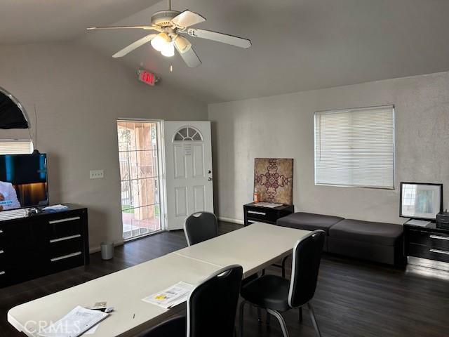 dining space with dark wood-type flooring, lofted ceiling, and a ceiling fan