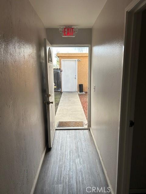 hall featuring baseboards and wood finished floors