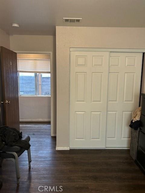 interior space featuring dark wood-style floors, visible vents, and baseboards