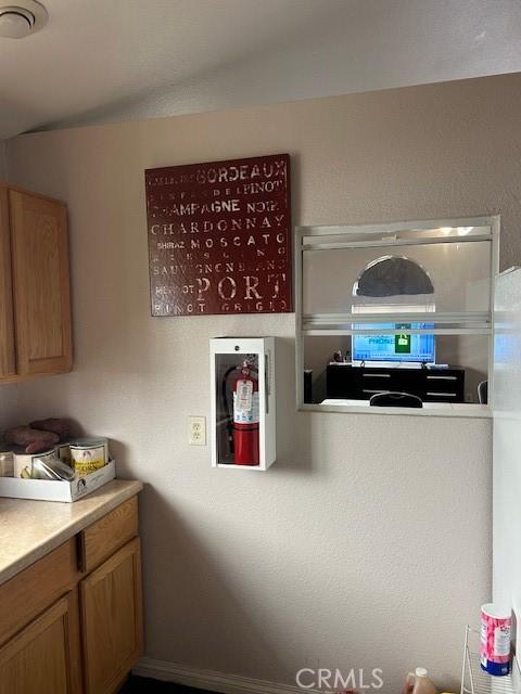 kitchen with brown cabinets, light countertops, and baseboards