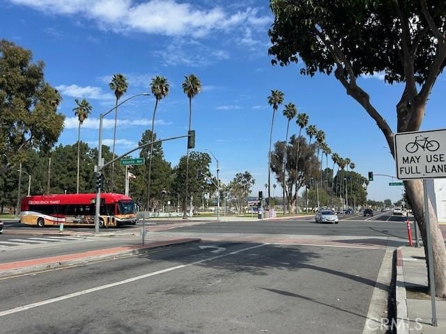 view of road with street lighting, curbs, sidewalks, and traffic lights