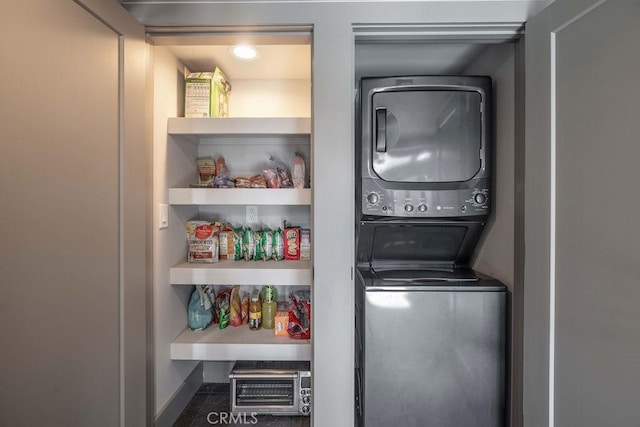 clothes washing area featuring stacked washer / dryer