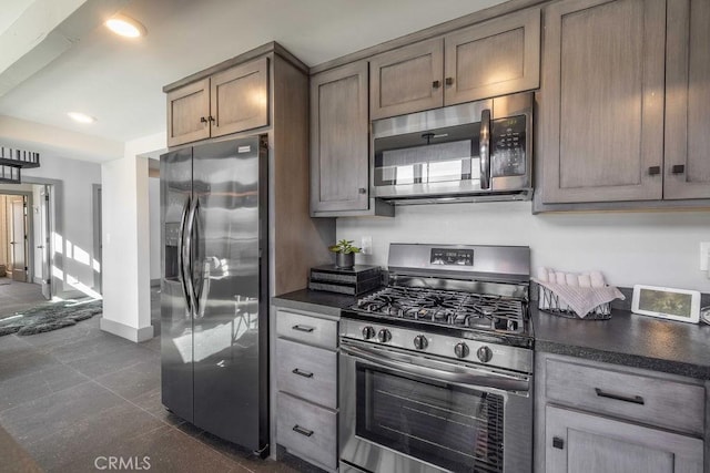 kitchen featuring stainless steel appliances, recessed lighting, dark countertops, and baseboards