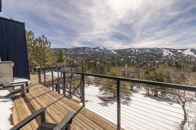 snow covered deck with a mountain view